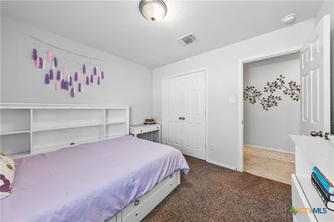 a bedroom with a bed and a refrigerator