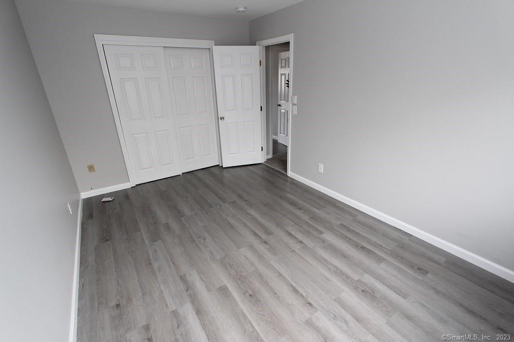 1400 Meriden Road, Unit 52 Waterbury, CT 06705 - Photo 16 of 21 a view of an empty room with wooden floor