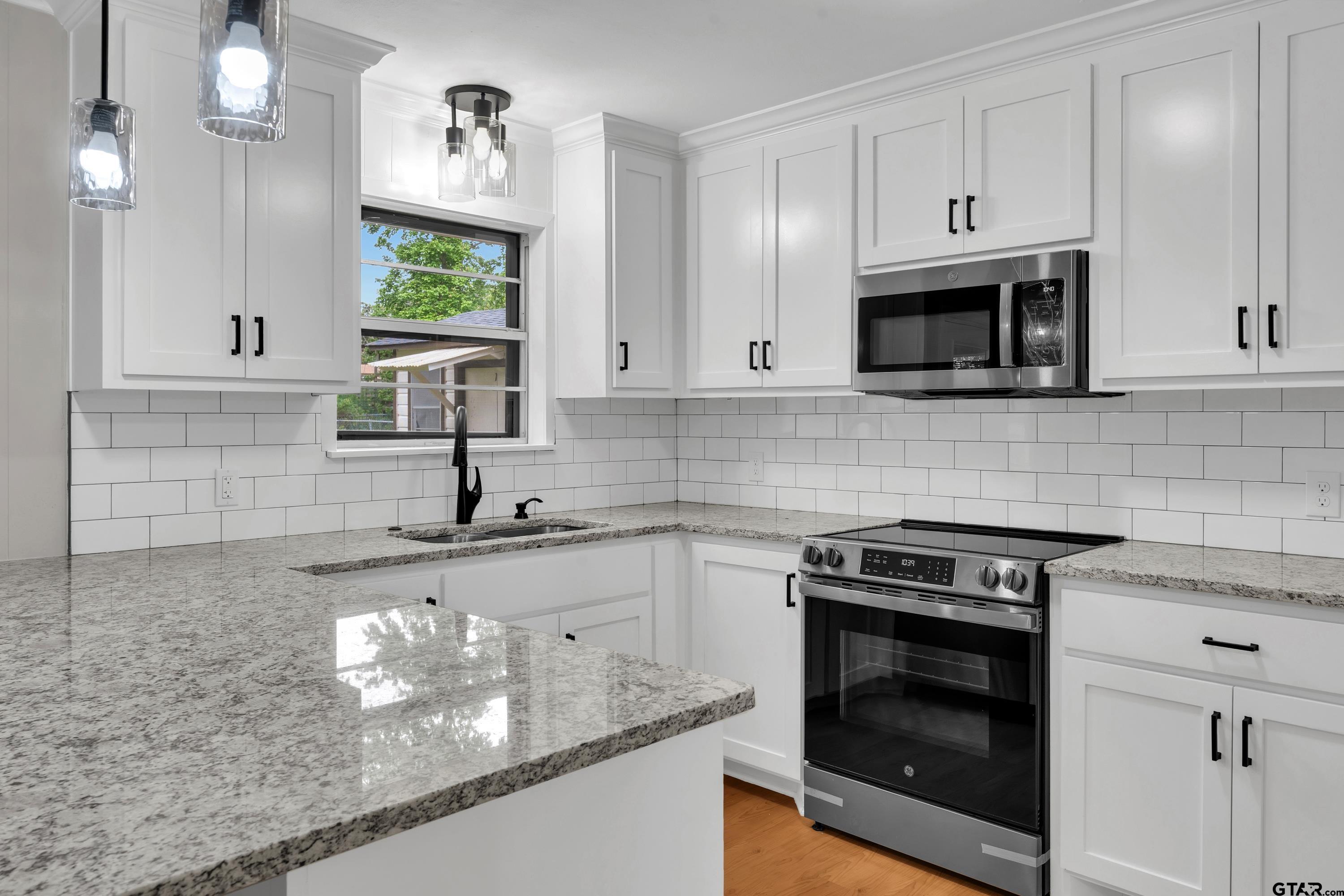 12813 Sunset Drive Tyler, TX 75704 - Photo 12 of 34 a kitchen with granite countertop white cabinets stainless steel appliances and a sink