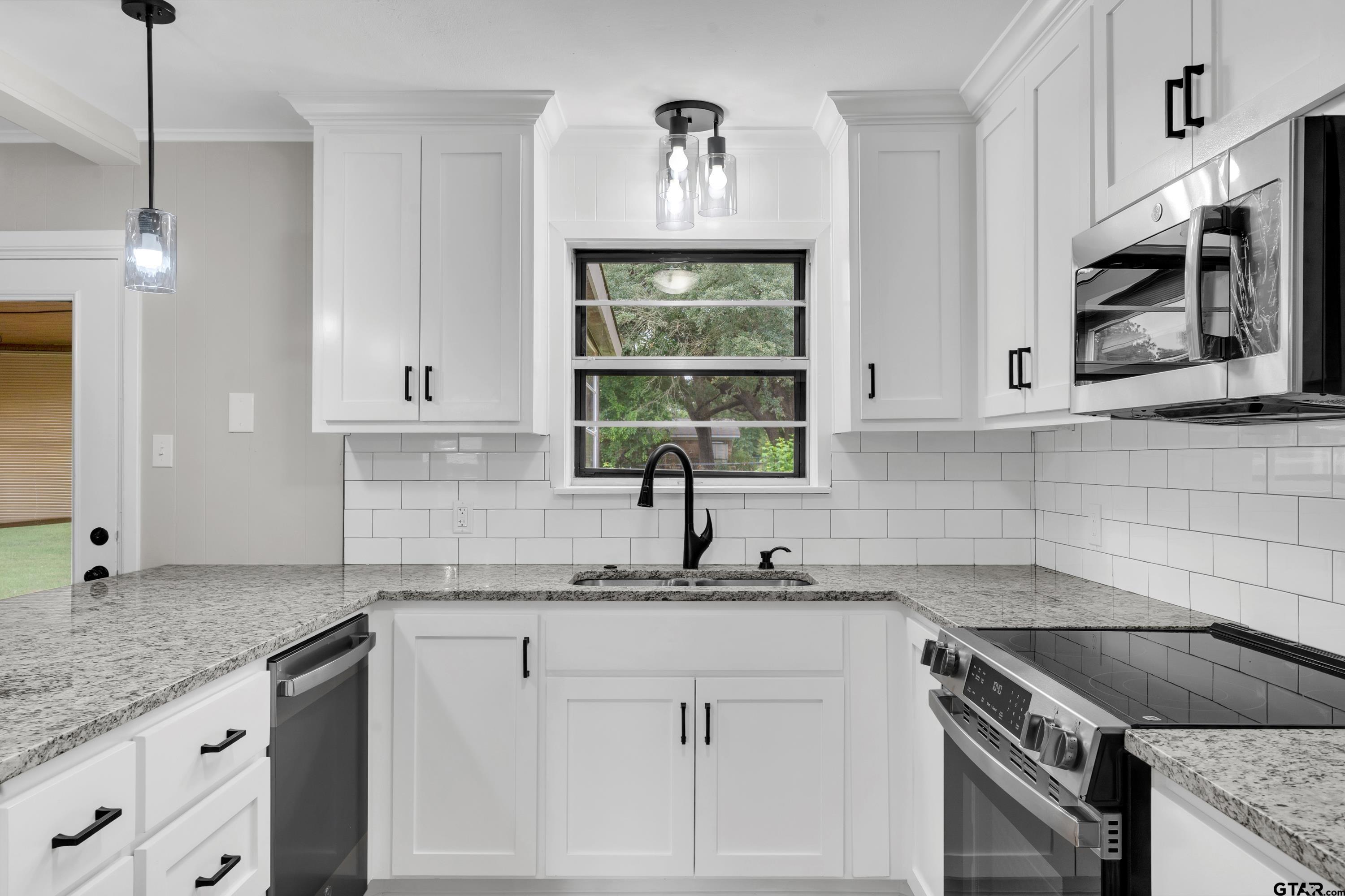 12813 Sunset Drive Tyler, TX 75704 - Photo 13 of 34 a kitchen with granite countertop a sink stainless steel appliances and cabinets