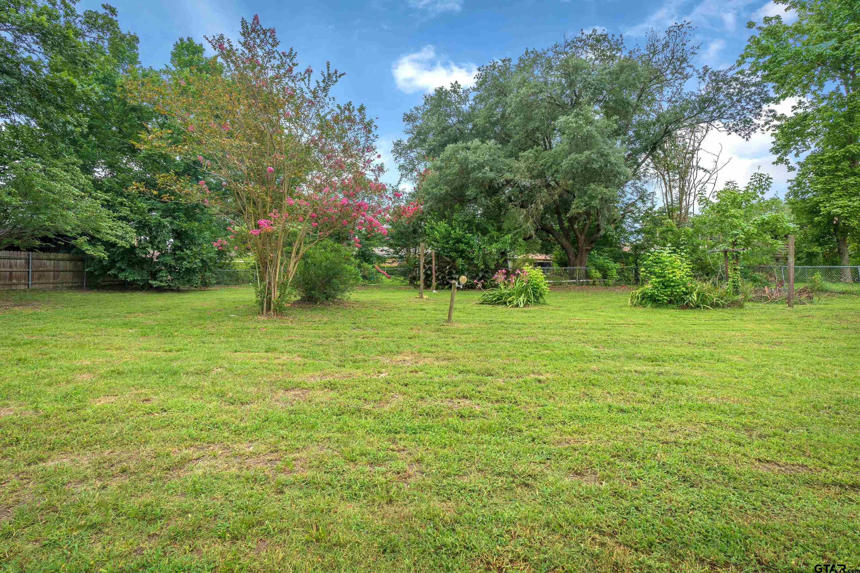12813 Sunset Drive Tyler, TX 75704 - Photo 26 of 34 a view of a green field with trees in the background