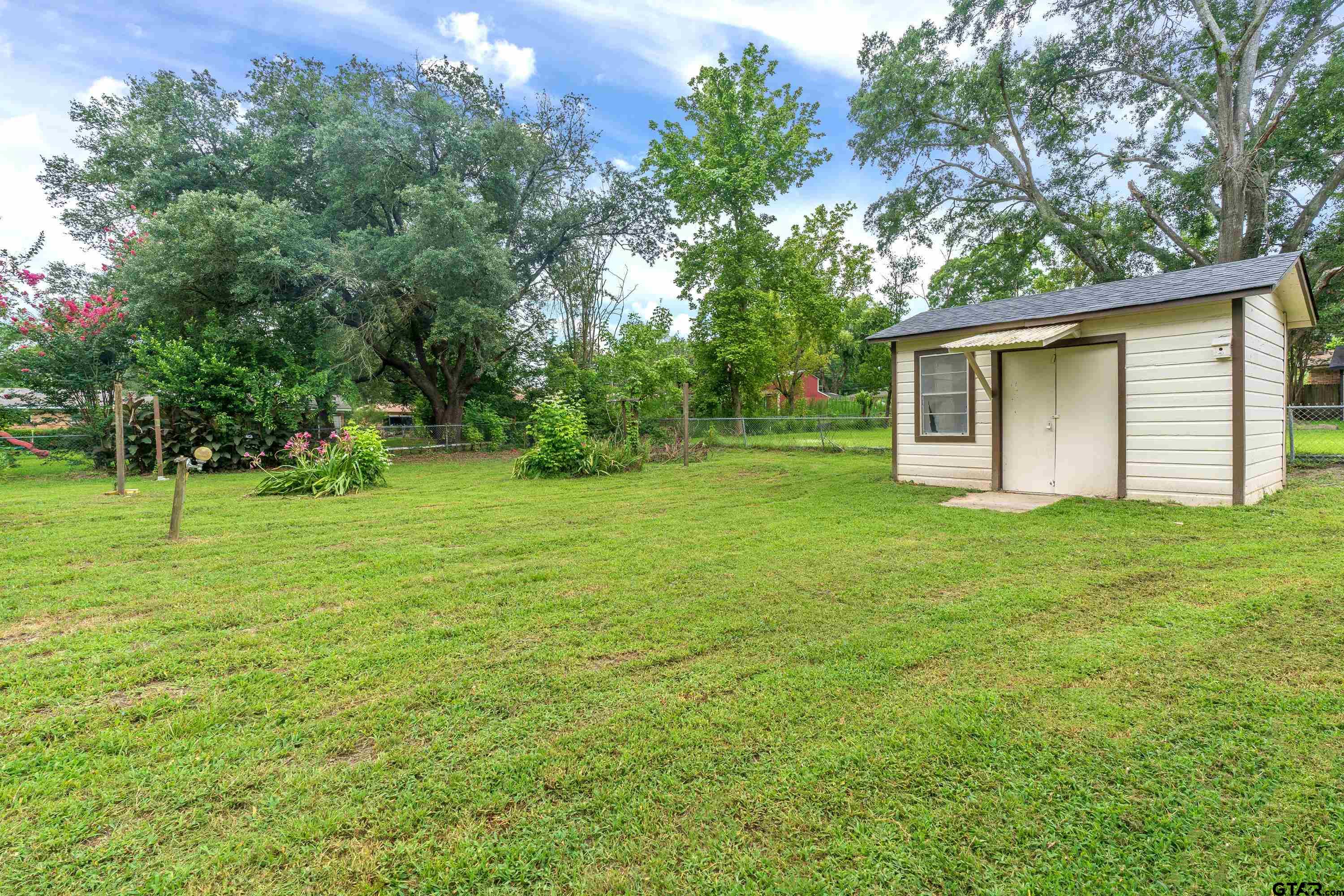 12813 Sunset Drive Tyler, TX 75704 - Photo 27 of 34 a backyard of a house with plants and large trees