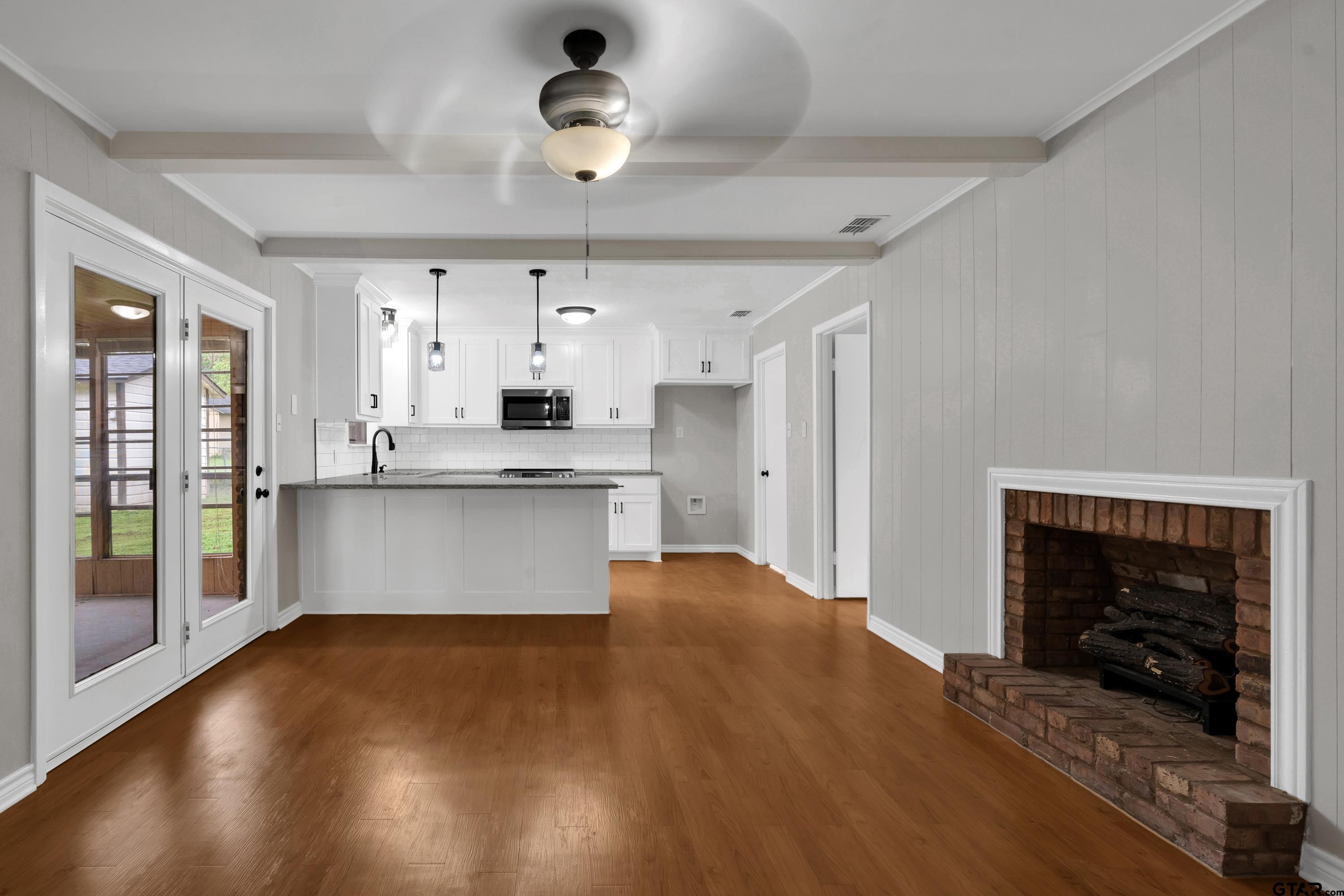 12813 Sunset Drive Tyler, TX 75704 - Photo 6 of 34 a large kitchen with stainless steel appliances granite countertop a stove oven a refrigerator with a fireplace and wooden floor