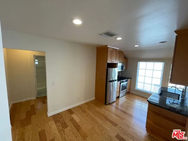 a kitchen with a refrigerator sink and wooden floor