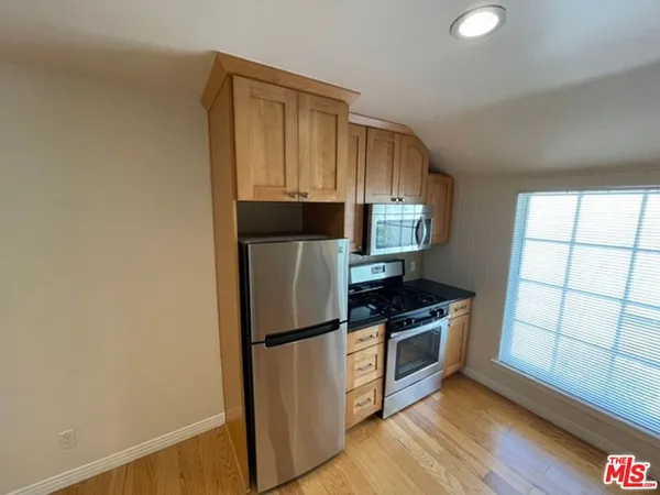 a kitchen with a refrigerator a stove a microwave and cabinets