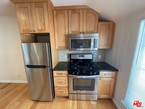 a kitchen with appliances a microwave and cabinets