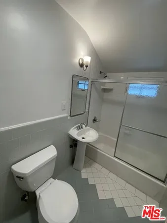 a bathroom with a toilet a sink and a mirror
