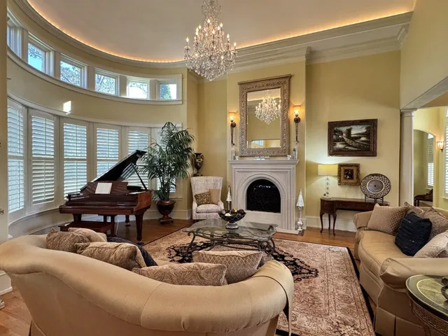 a living room with furniture a fireplace and a large window