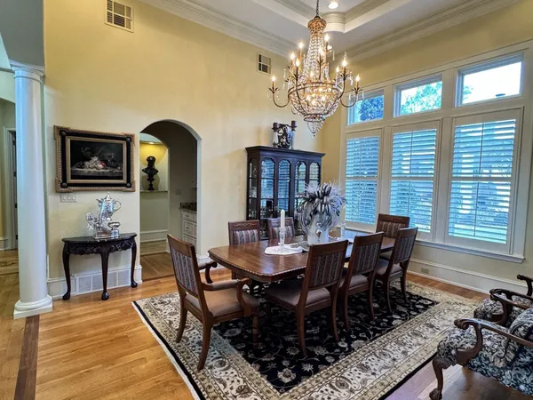 a view of a dining room with furniture a chandelier and wooden floor