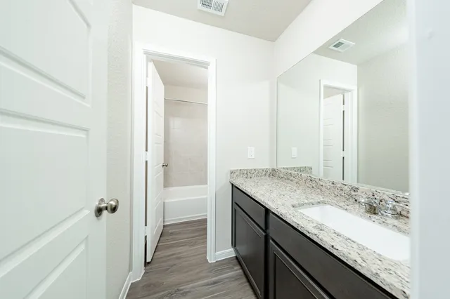 a bathroom with a granite countertop sink and a mirror