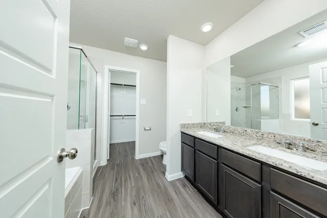 a en suite bathroom with a granite countertop sink toilet and shower