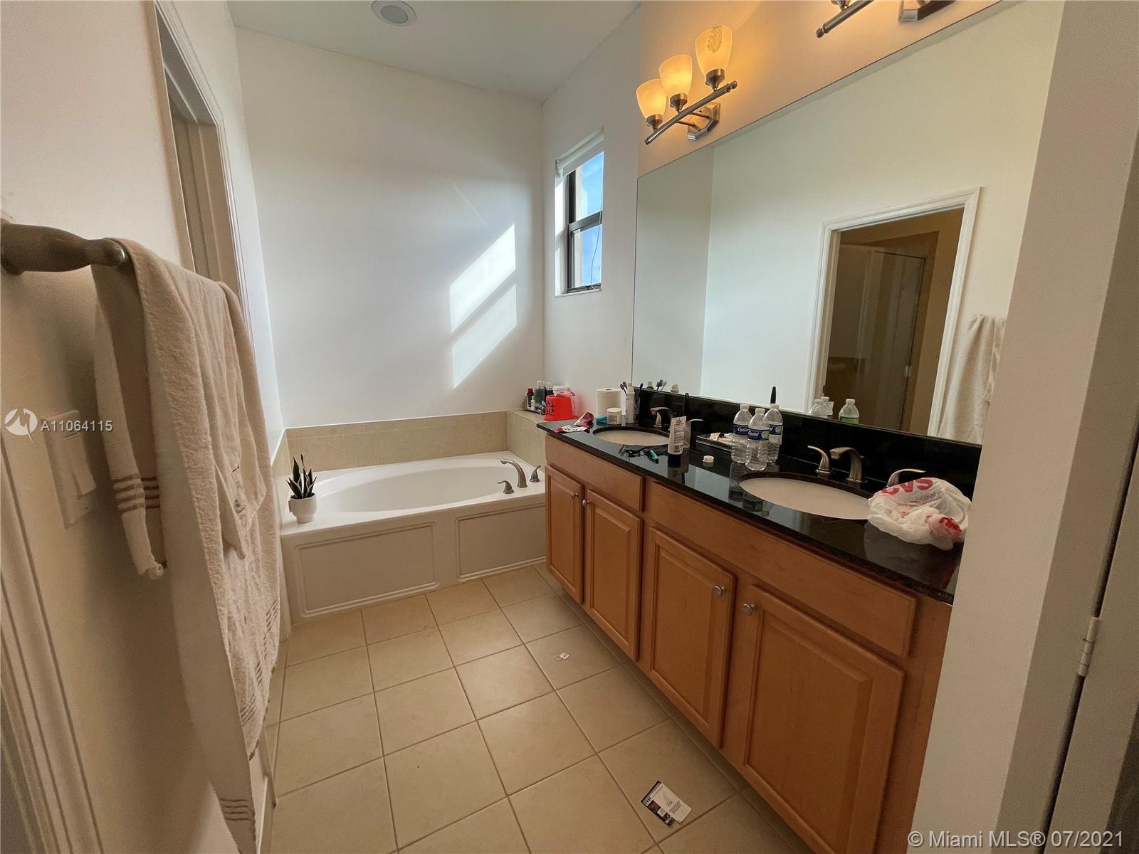 631 Northeast 191st Terrace Miami, FL 33179 - Photo 14 of 28 a bathroom with a bathtub sink and mirror