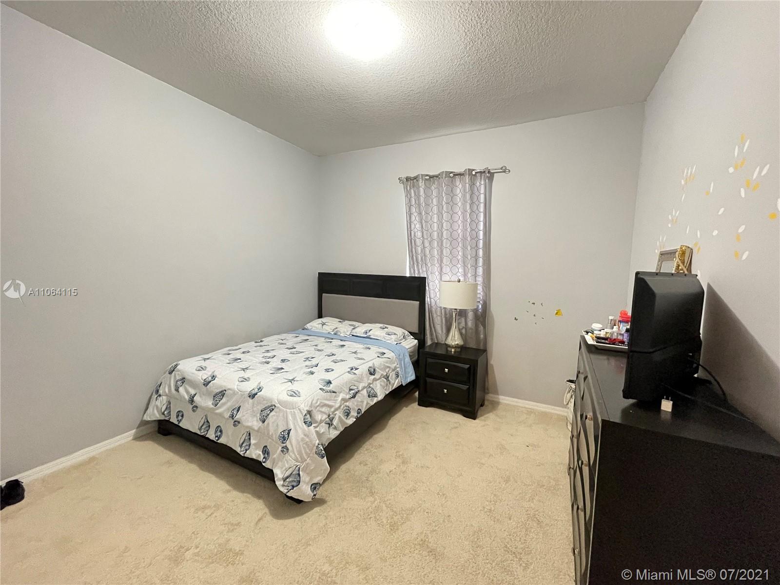 631 Northeast 191st Terrace Miami, FL 33179 - Photo 18 of 28 a bedroom with a bed and a computer on the desk