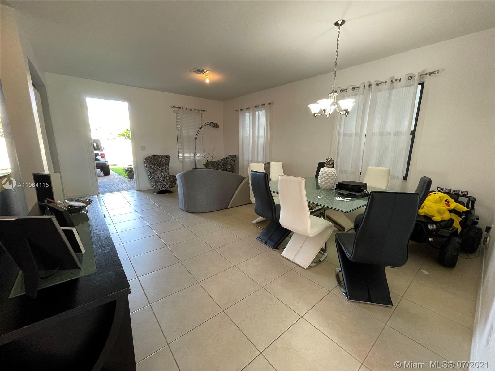 631 Northeast 191st Terrace Miami, FL 33179 - Photo 4 of 28 a living room with furniture and a chandelier