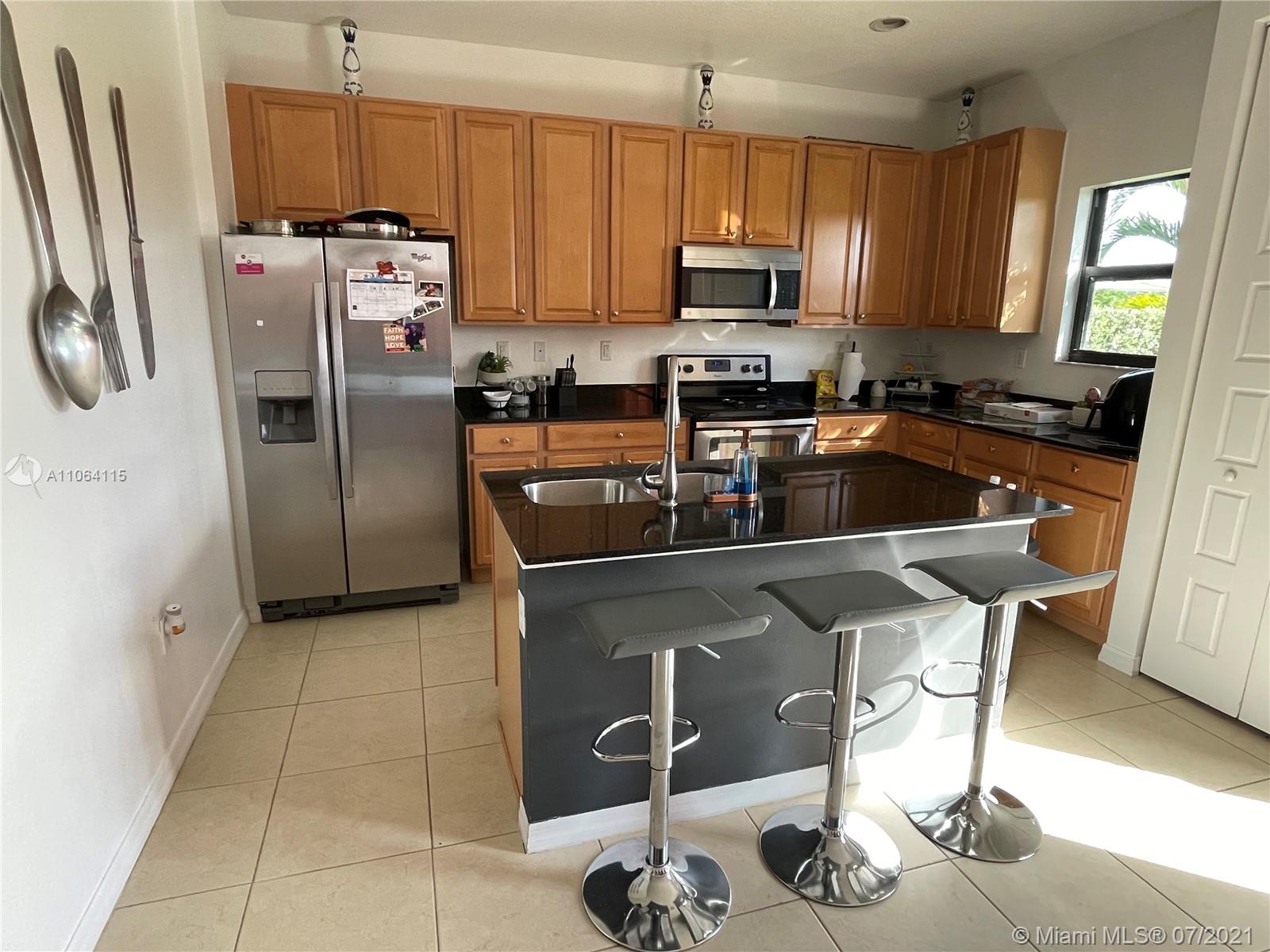 631 Northeast 191st Terrace Miami, FL 33179 - Photo 6 of 28 a kitchen with stainless steel appliances granite countertop a sink refrigerator and microwave