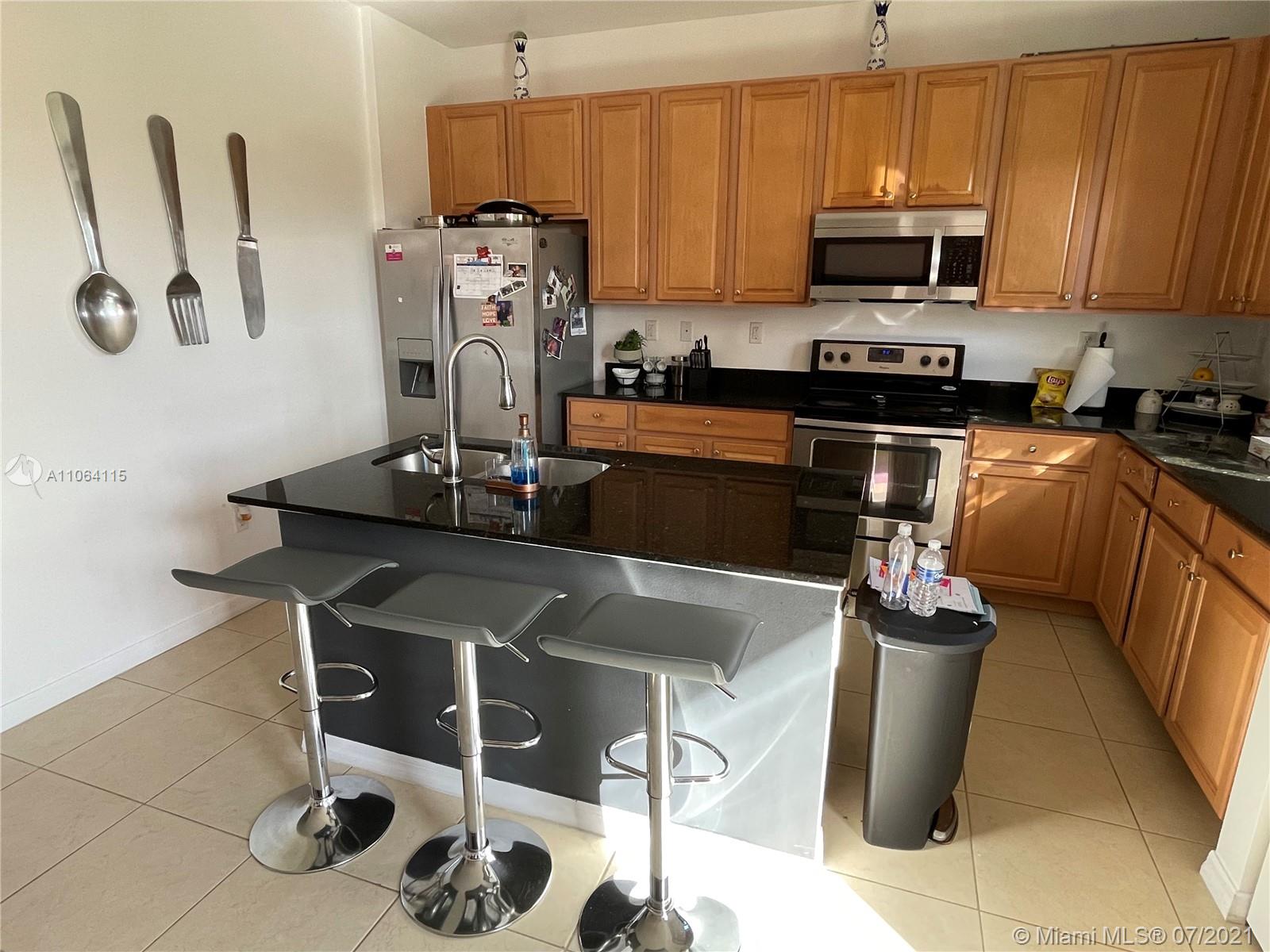 631 Northeast 191st Terrace Miami, FL 33179 - Photo 7 of 28 a kitchen with stainless steel appliances granite countertop a sink a stove top oven a counter space and cabinets