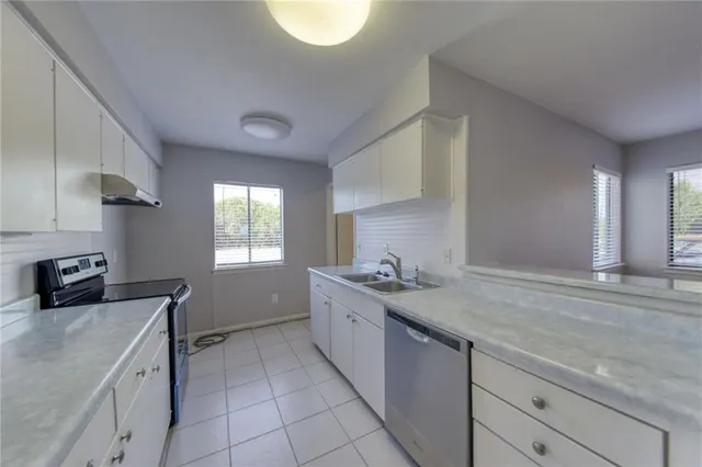 a kitchen with a sink stove and cabinets