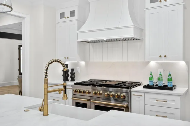 a kitchen with white cabinets and window