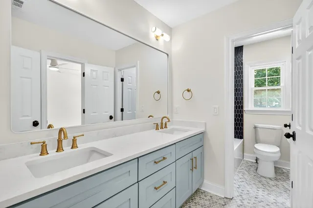 a bathroom with a sink a toilet and shower