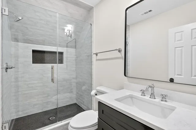 a bathroom with a sink a toilet and shower