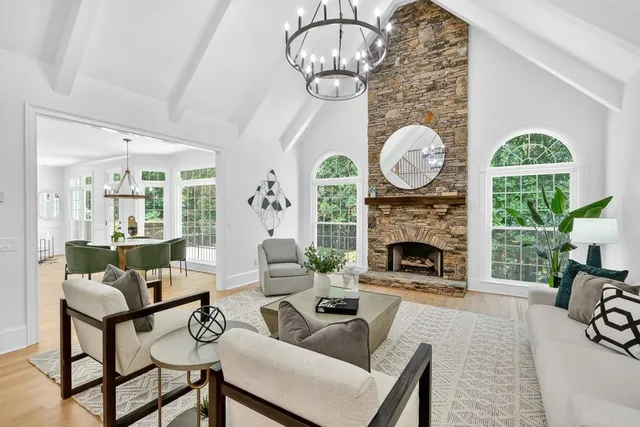 a living room with furniture a fireplace and a large window