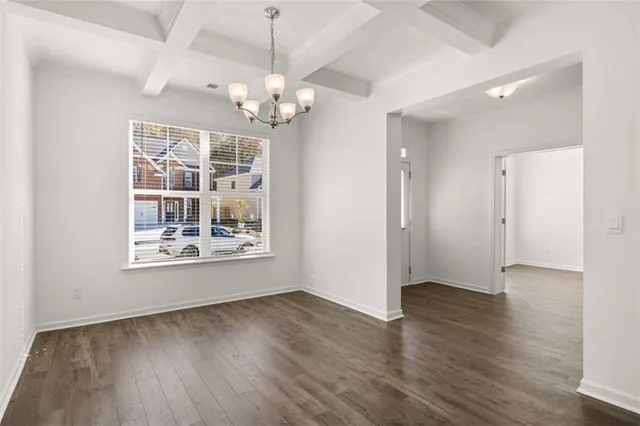 a view of empty room with wooden floor and window