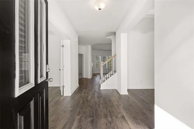 a view of a hallway with wooden floor and a dining room