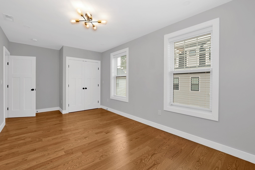34 Temple Street Boston, MA 02126 - Photo 17 of 38 a view of an empty room with wooden floor and a window
