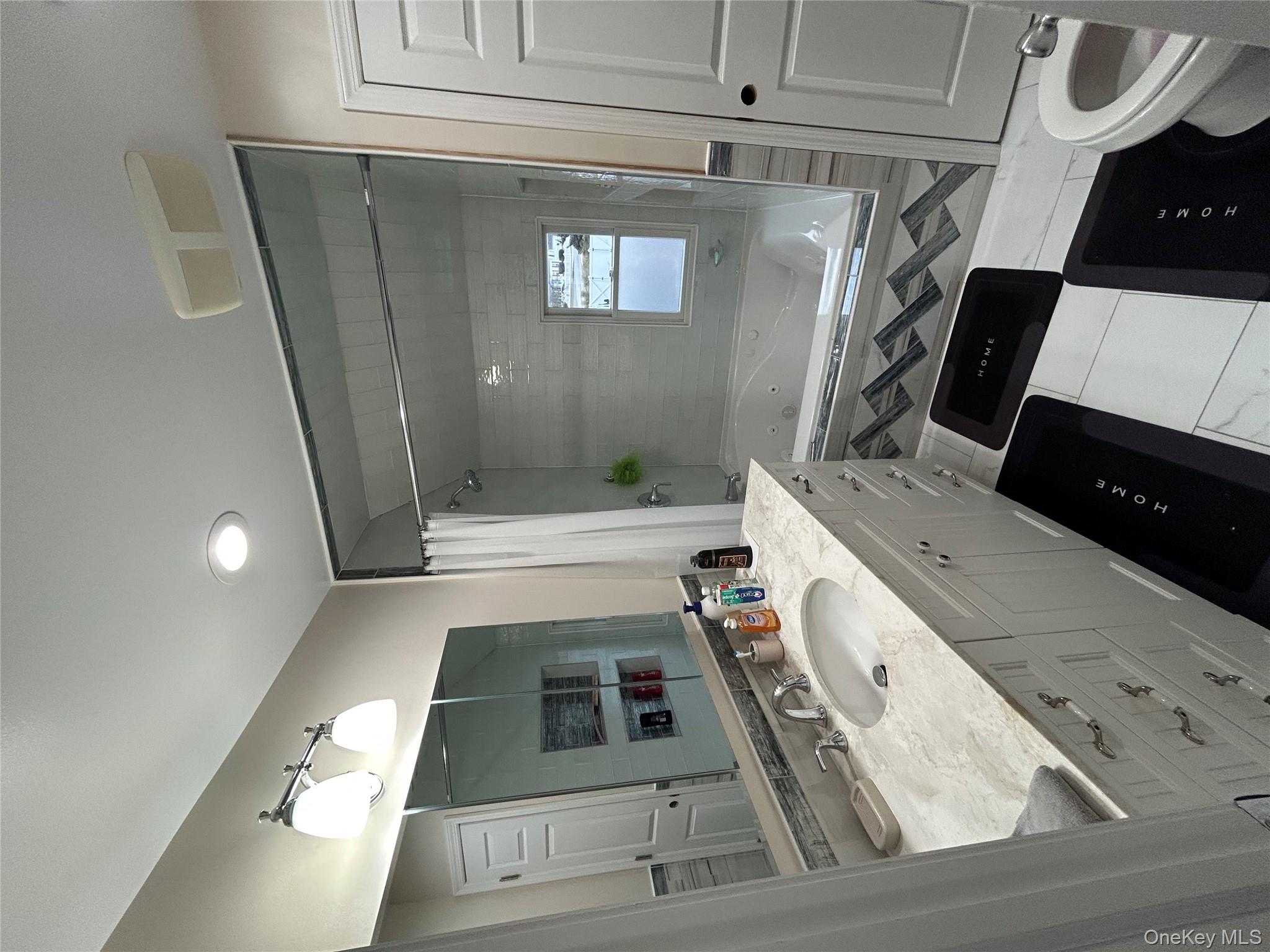 869 Demott Avenue Baldwin, NY 11510 - Photo 12 of 15 a bathroom with a double vanity sink toilet mirror and bathtub