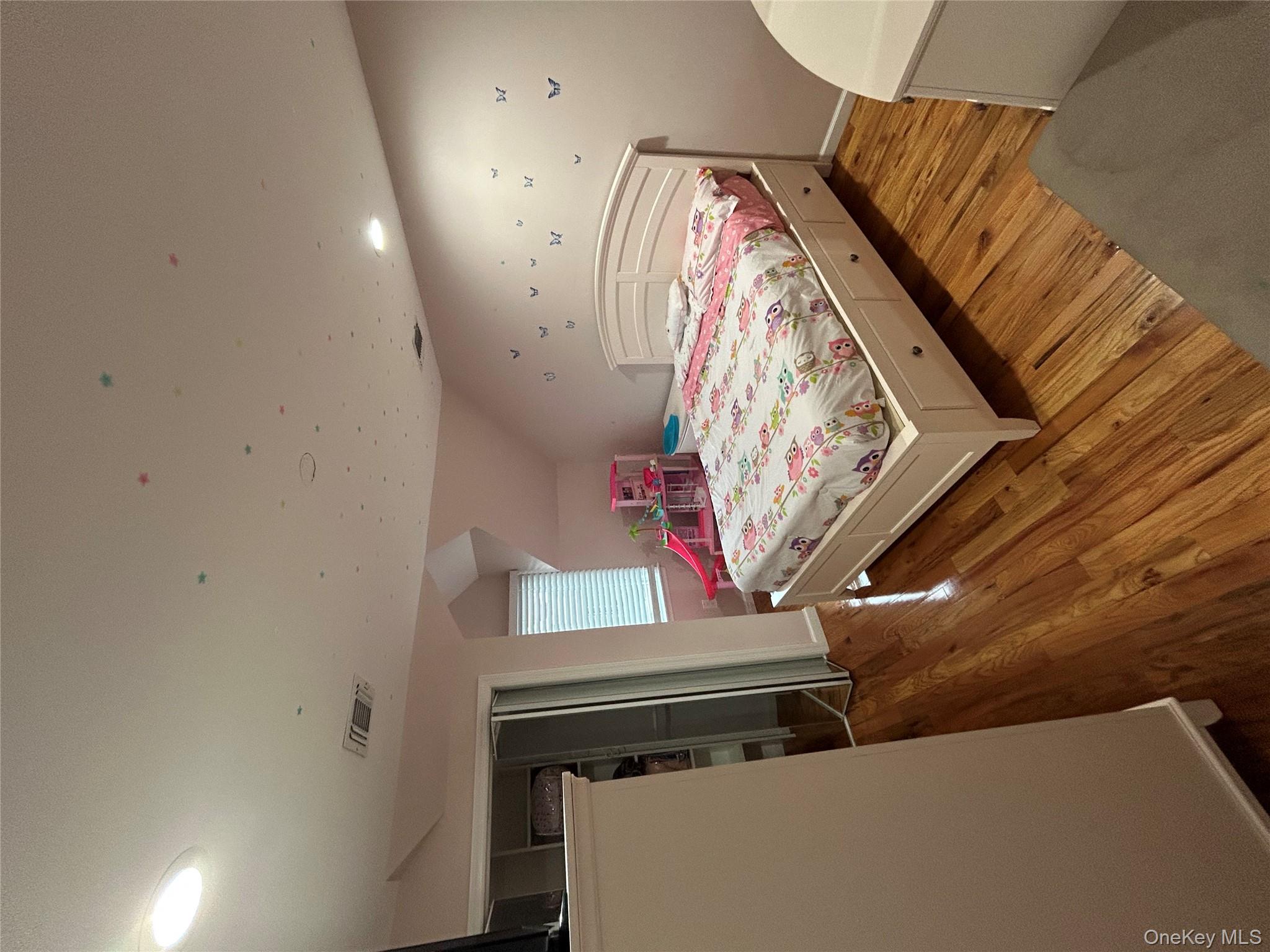 869 Demott Avenue Baldwin, NY 11510 - Photo 13 of 15 a bedroom with a bed and a flat screen tv