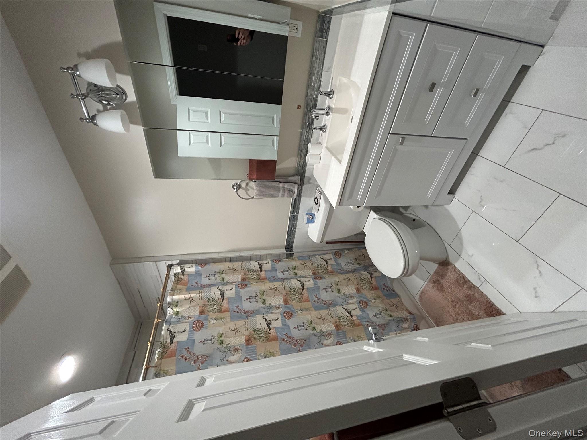 869 Demott Avenue Baldwin, NY 11510 - Photo 14 of 15 a bathroom with a double vanity sink mirror and toilet