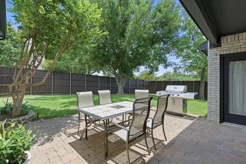 a view of a chairs and table in backyard