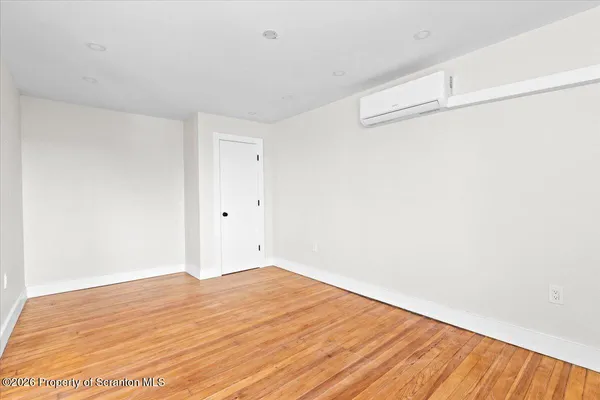 a view of empty room with wooden floor