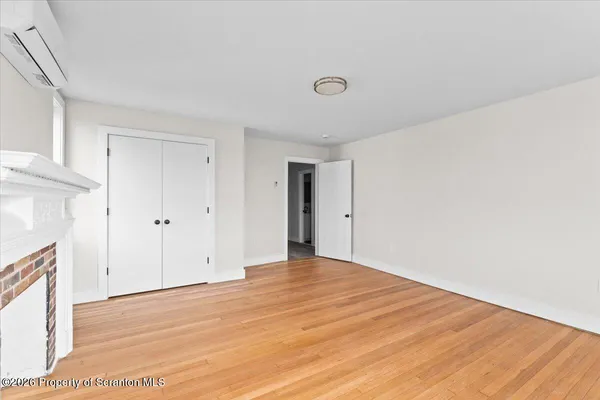 a view of empty room with wooden floor