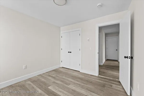 a view of an empty room with wooden floor