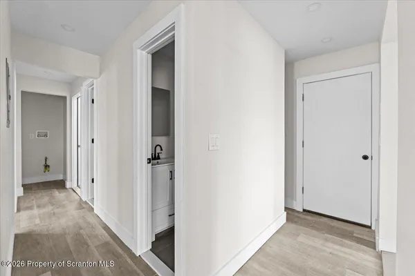a view of a hallway with closet and wooden floor