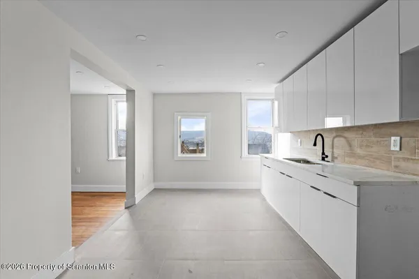 a large kitchen with granite countertop a sink stainless steel appliances and cabinets