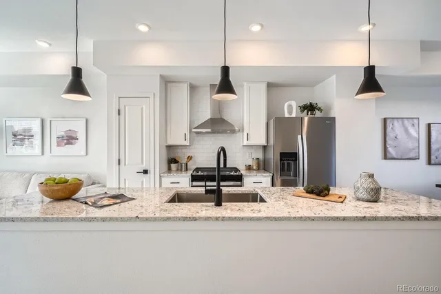 a kitchen with stainless steel appliances granite countertop a sink and a refrigerator
