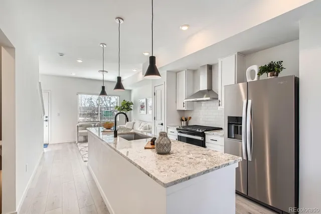 a kitchen with stainless steel appliances granite countertop a sink refrigerator and cabinets