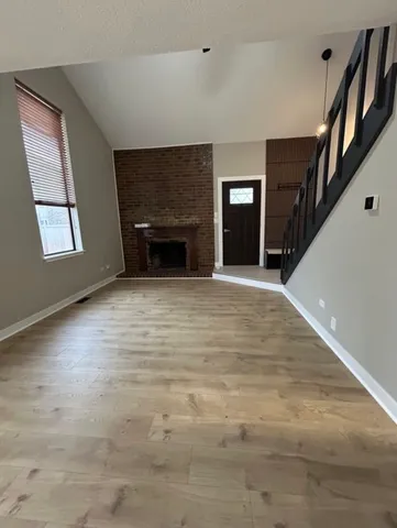 a view of an empty room with a fireplace and a window