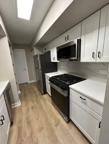 a kitchen with stainless steel appliances a stove microwave and sink