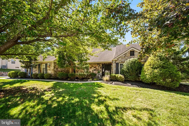a view of a house with a big yard and large trees