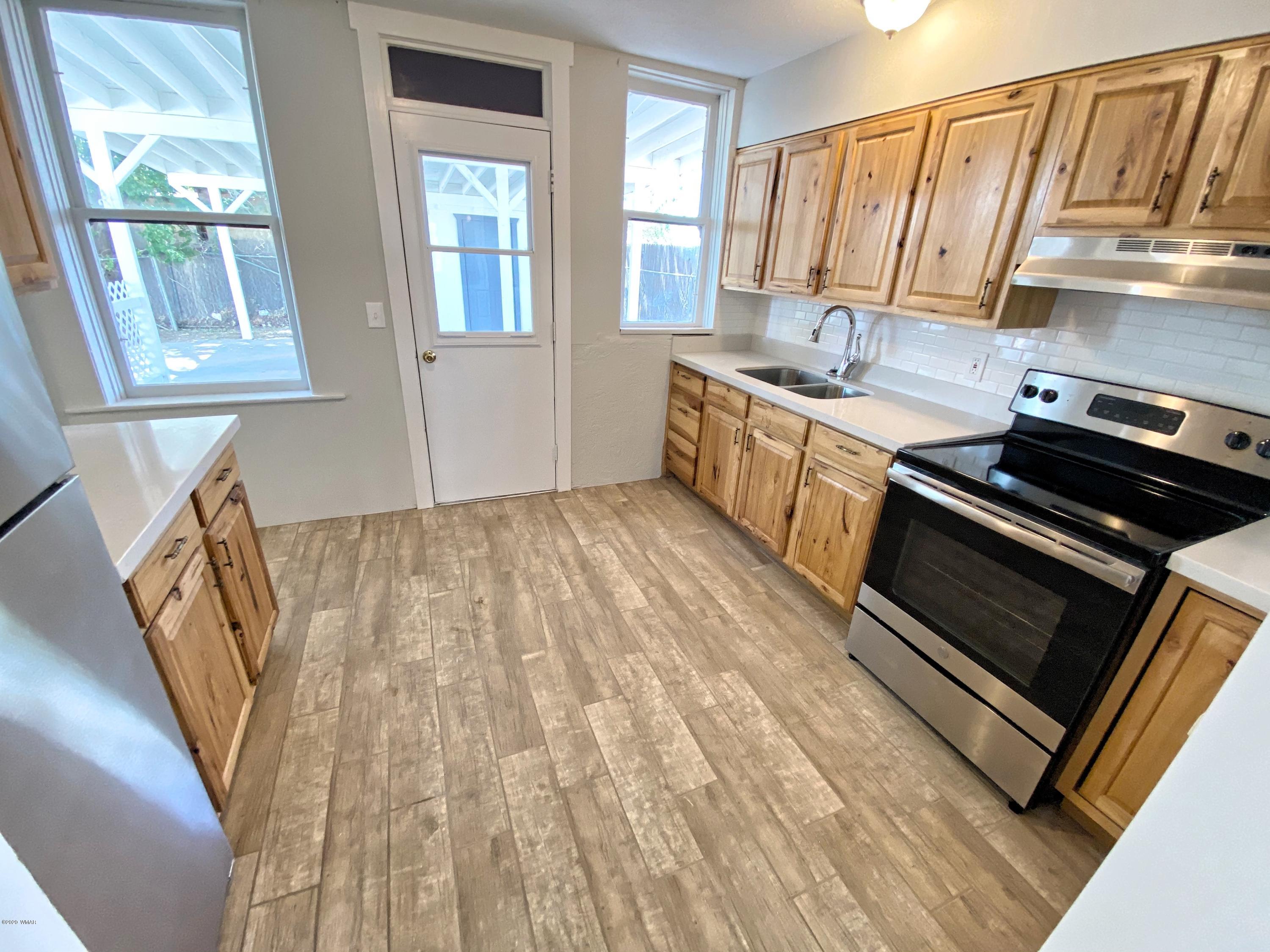 370 South 3rd Street West Snowflake, AZ 85937 - Photo 19 of 53 a kitchen with a sink a stove cabinets and a wooden floor