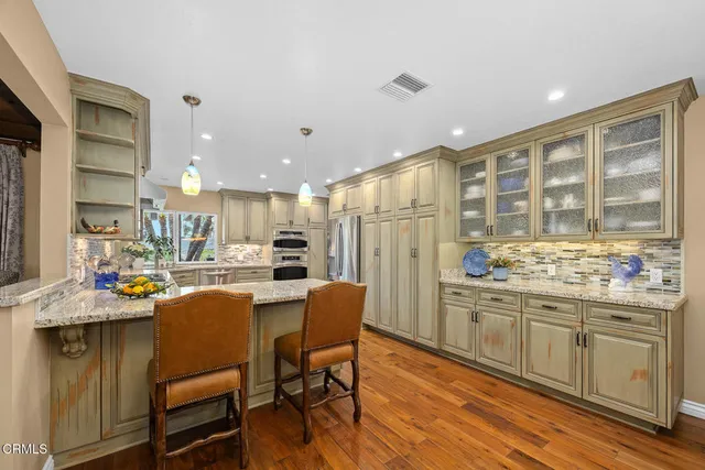 a kitchen with stainless steel appliances kitchen island granite countertop a sink and cabinets