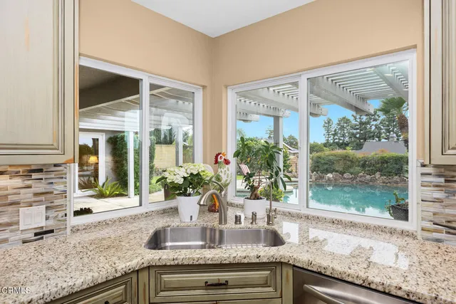 a kitchen with granite countertop sink and natural light