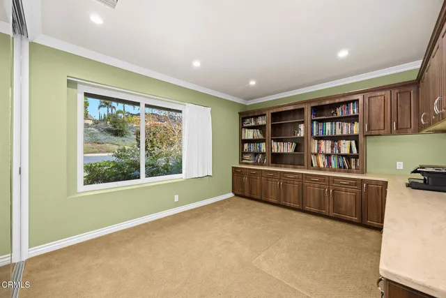 a view of a workspace with furniture and a window