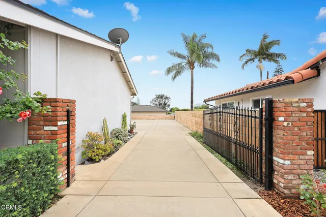 a view of a house with a yard and potted plants