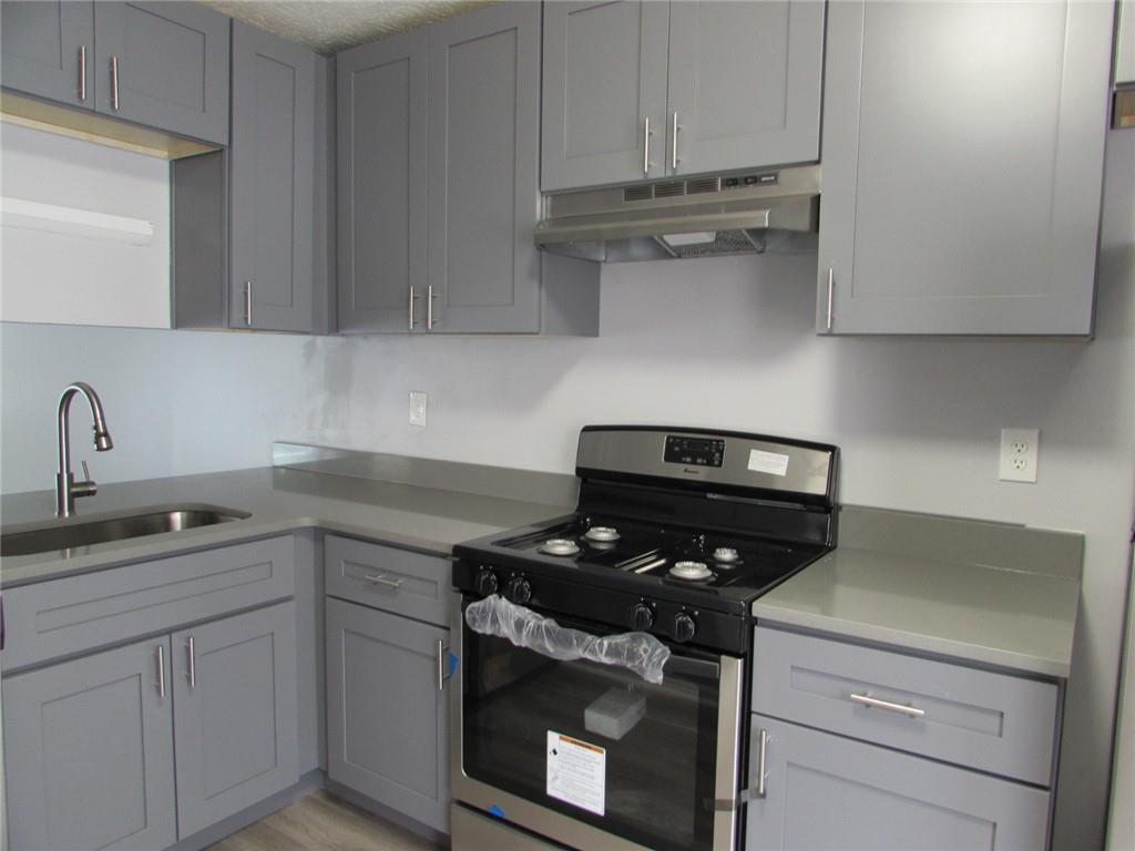 835 Heritage Valley Road Norcross, GA 30093 - Photo 10 of 34 a kitchen with stainless steel appliances granite countertop white cabinets and a stove top oven