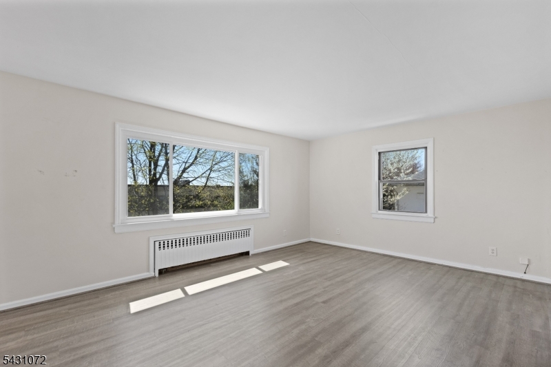 154 Ames Street Hackensack, NJ 07601 - Photo 5 of 12 an empty room with wooden floor and windows