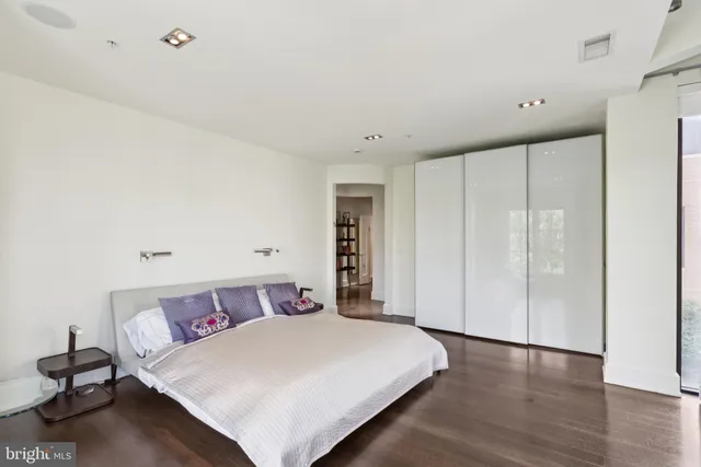 a bedroom with a large bed and wooden floor